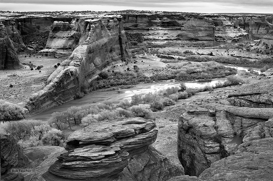 Blade rock protrudes out from the distant canyon wall into the wash forcing the river to divert around it on a rainy early morning...