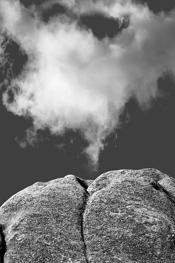 An interesting rock formation resembles a mouth with pursed lips. The delicate cloud passing overhead appears as smoke that has...