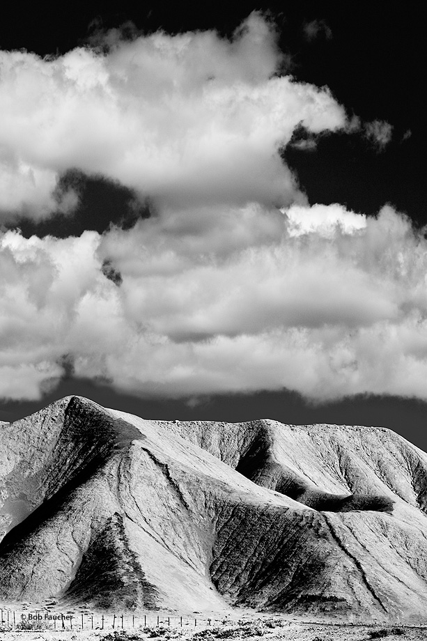 Early morning light accentuates the texture of the hills and clouds