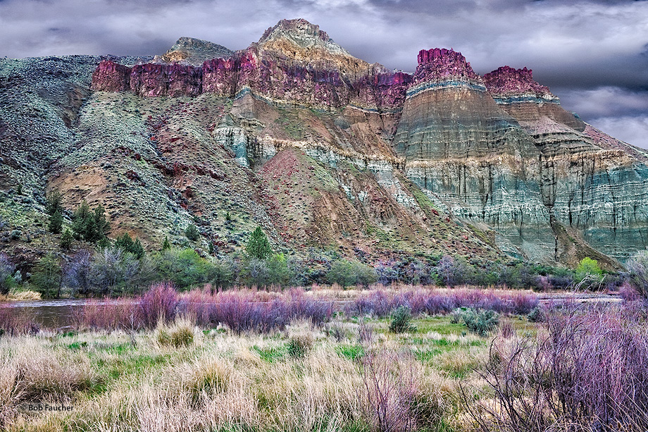 Majestic Cathedral Rock rises above the John Day River on a rainy cloudy day.The colors you see are due to the chemicals in the...