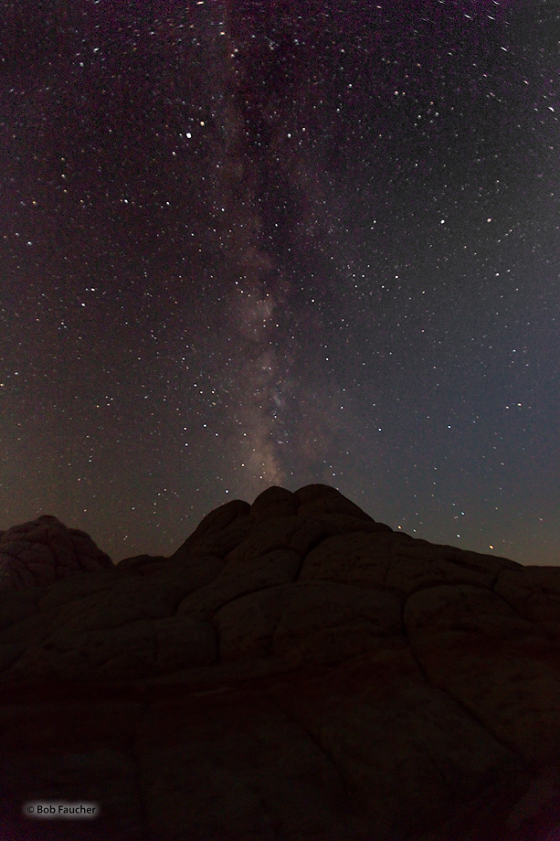 The Milky Way appears to be erupting from the top of the rock formation