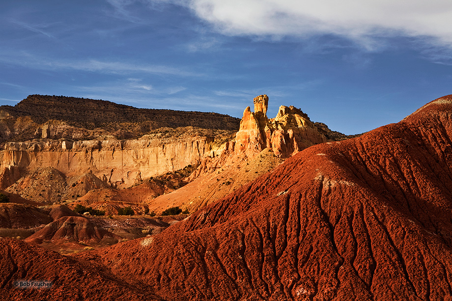 With badlands surrounding it and graced by late afternoon sun, Chimney Rock appears gloriously above Ghost Ranch, near Abiquiu...