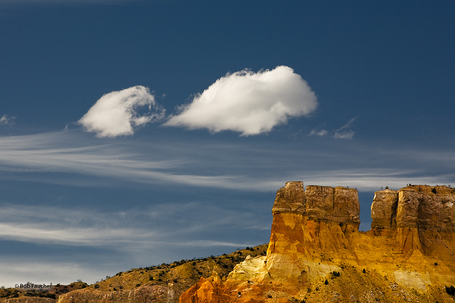 A smaller cloud, with a semingly demonic face, gaping mouth and snaggled teeth, appears to be chasing a larger cloud past an...