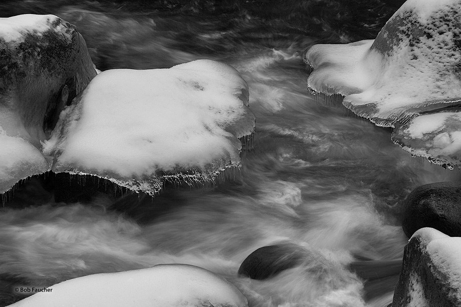 Ice and snow shelves form on the sides of rocks along the river. These, in turn, form icicles from snow melt and water splashed...