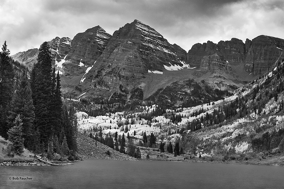 Storm clouds hang ominously over the peaks of the Maroon Bells. Yet a beam of sumlight manages to penetrate through the clouds...