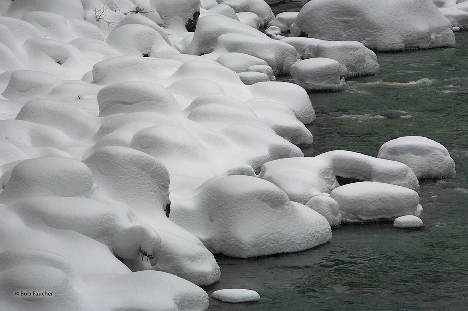 Riverside rocks are covered with a heavy coat of recent snow making them appear as though the have been coated with marshmallow...