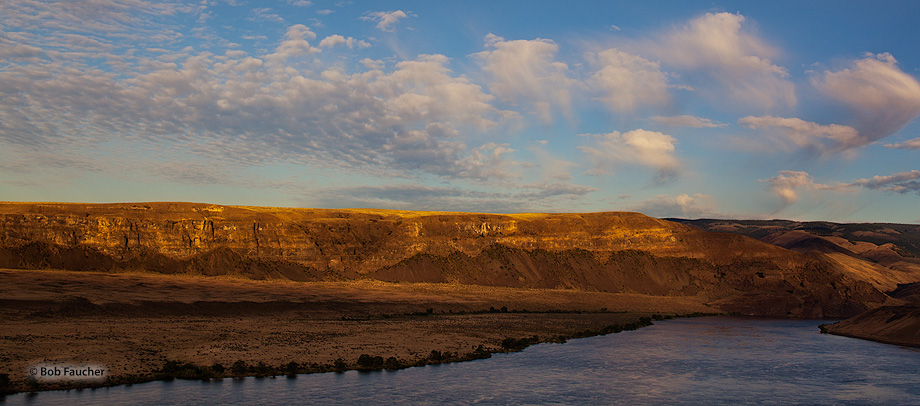 First light hits the cliff banks of the Columbia River and overhead clouds near Trinidad, Washington