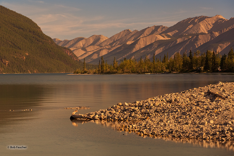 Morning sun warms the alluvial scree on the beach as well as the hills beyond Muncho Lake