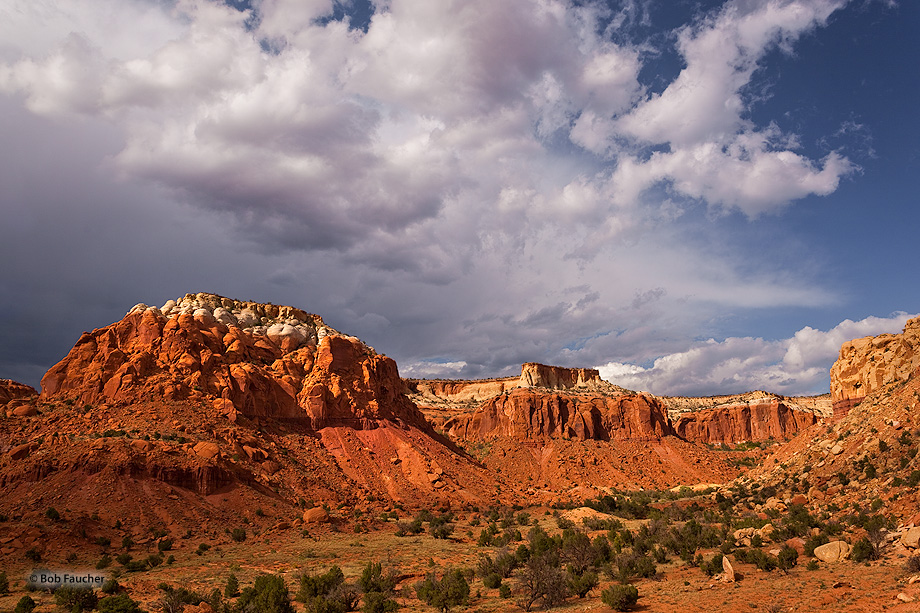 The glowing rocks of Piedra Lumbre in afternoon light with cumulus clouds overhead