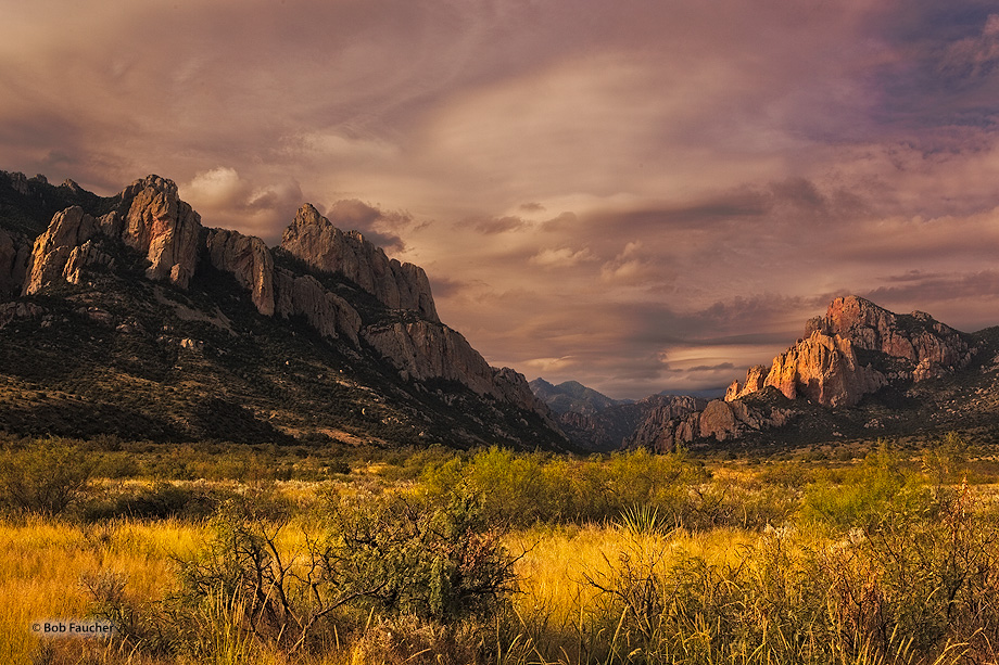 Morning sunlight comes under the storm clouds from the previous night to highlight the walls and plains at the entrance to Cave...