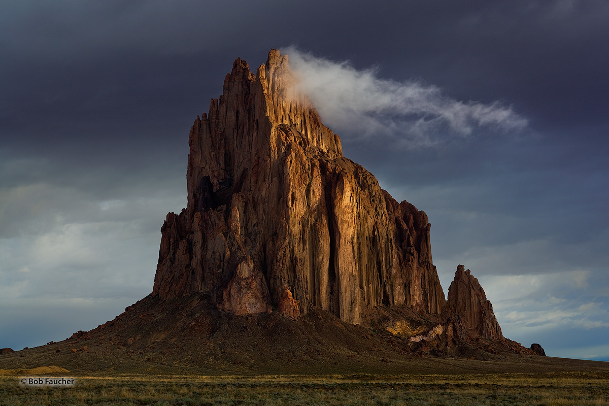 Shiprock, a diatremic monadnock, rises abruptly from the virtually level surrounding plain. The east face reflects morning sunlight...