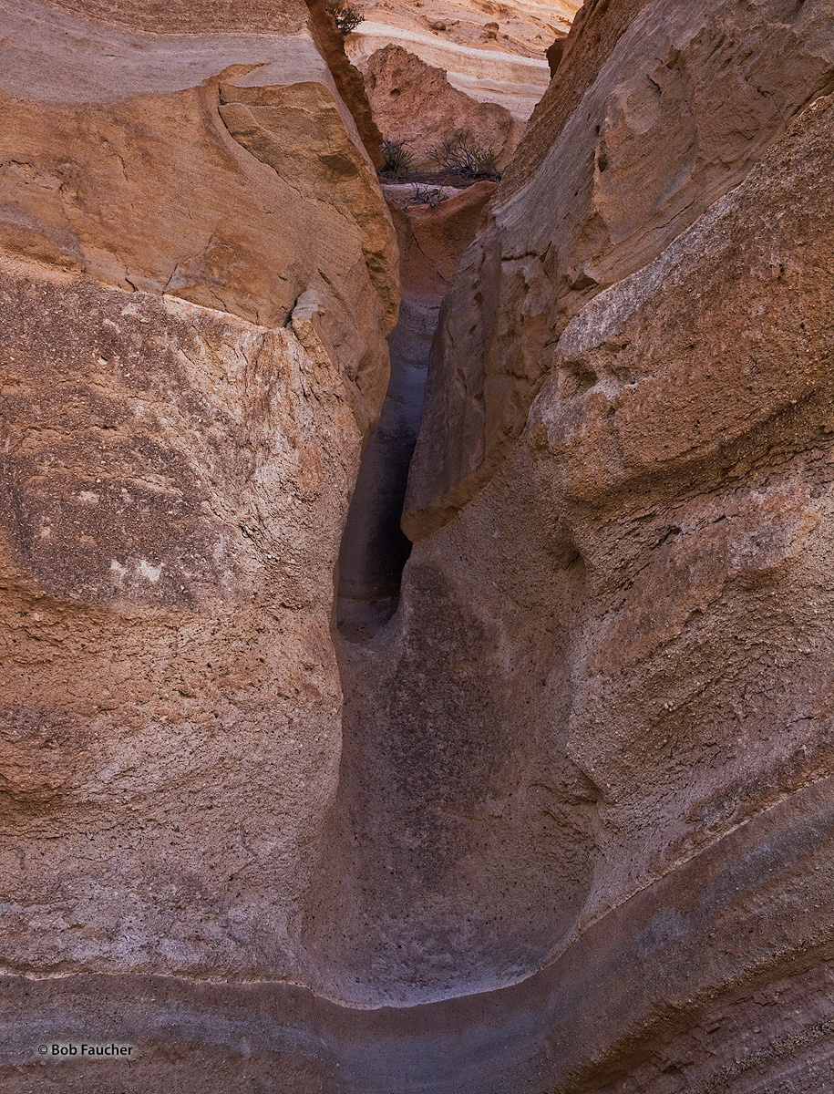 The smooth walls and floor of a small water-eroded slot canyon are much less abrasive than the adjoining walls at it's exit