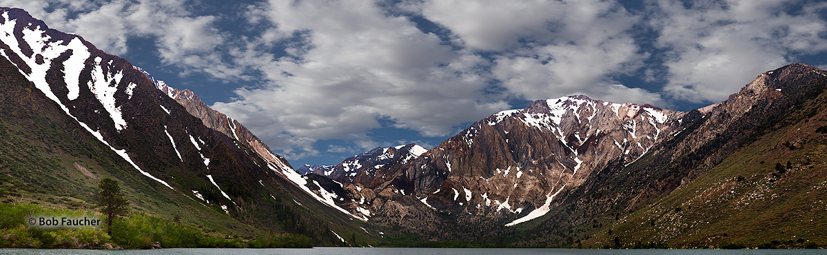 Morning sunshine filters through broken cloud cover to light up the mountains surrounding Convict Lake in the Sherwin Range of...