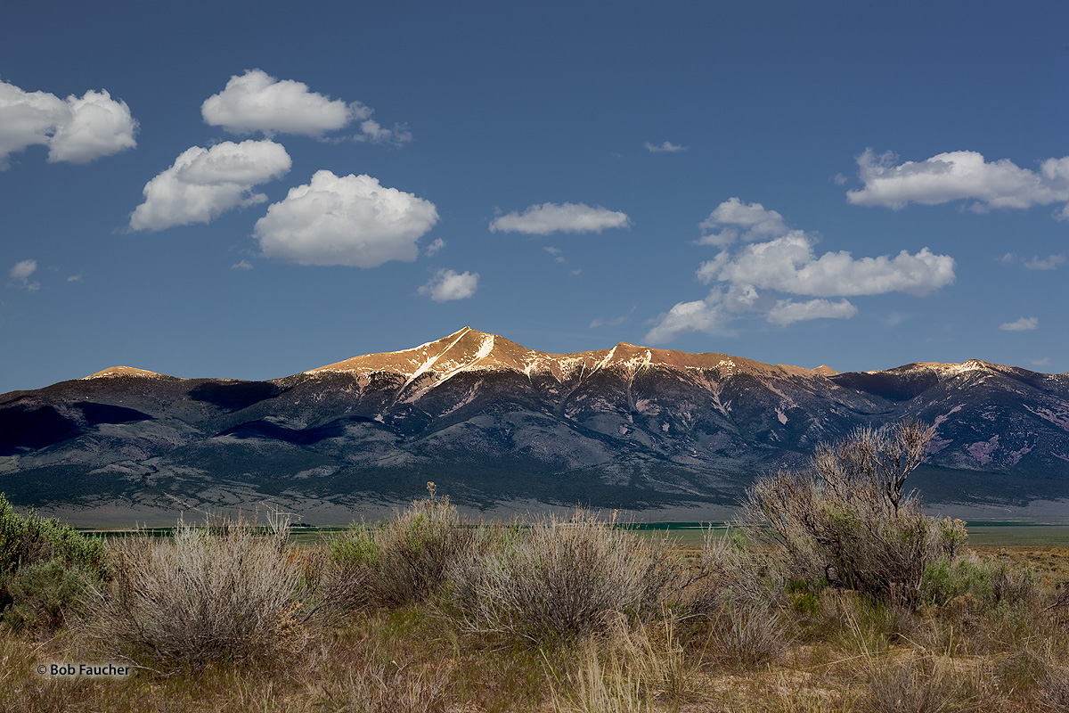 With the Schell Creek Range casting a shadow across Spring Valley and up ithe west face of Wheeler Peak, only the higher reaches...