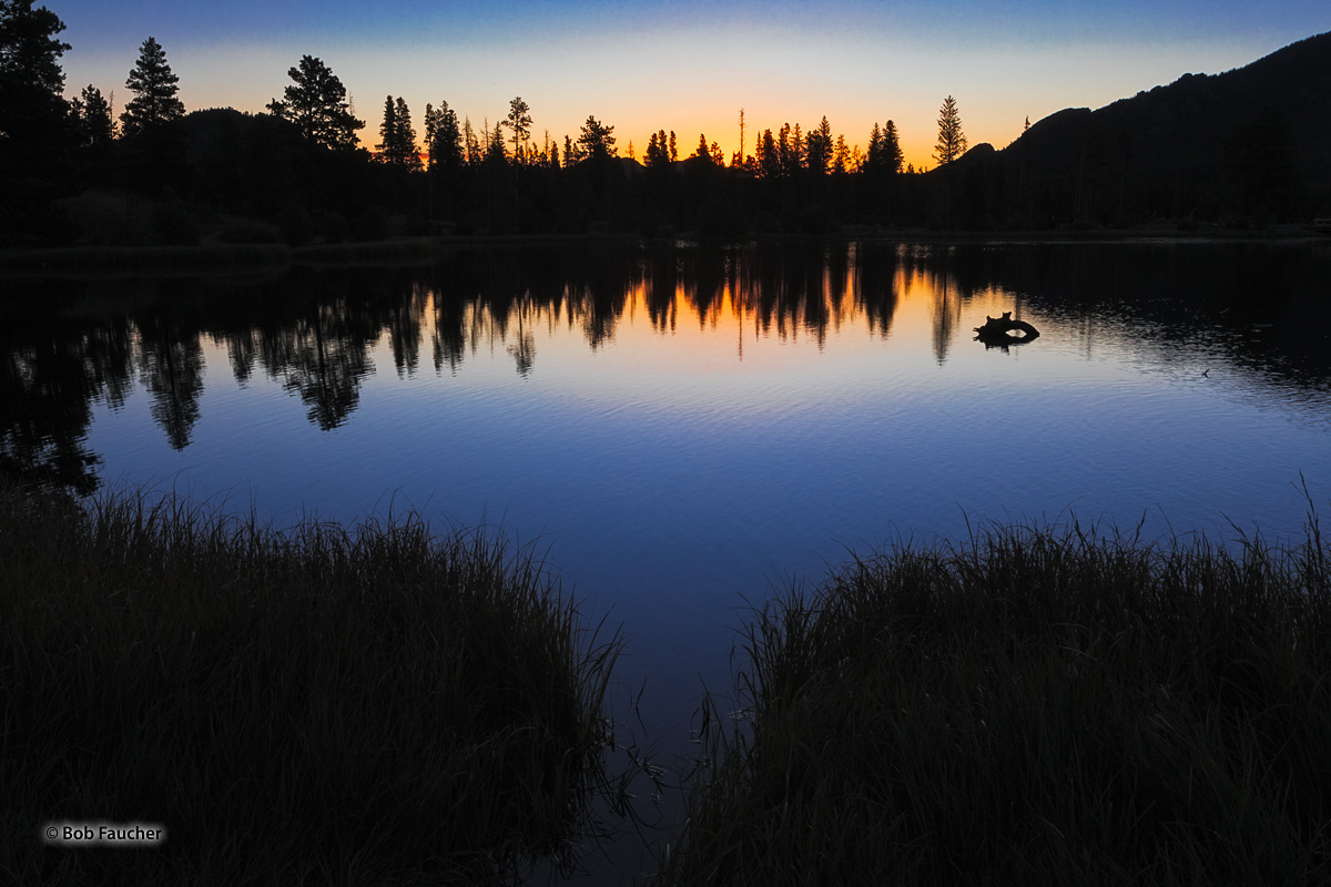 The quietness of dawn allows its spectacular colors to be perfectly reflected on the undisturbed surface of Sprague Lake