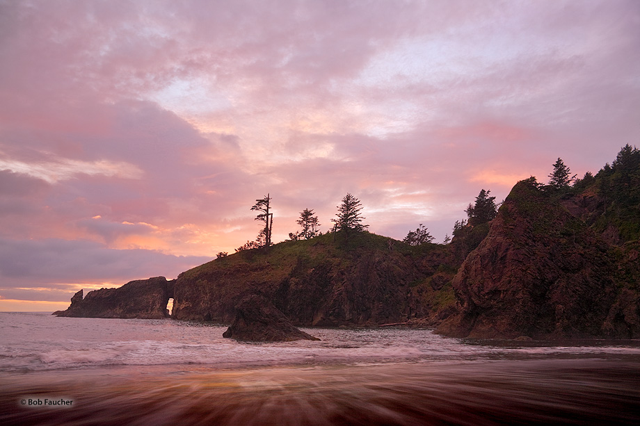 After the sun has dropped below the horizon the clouds remain illuminated and reflect the warm light onto the landscape.