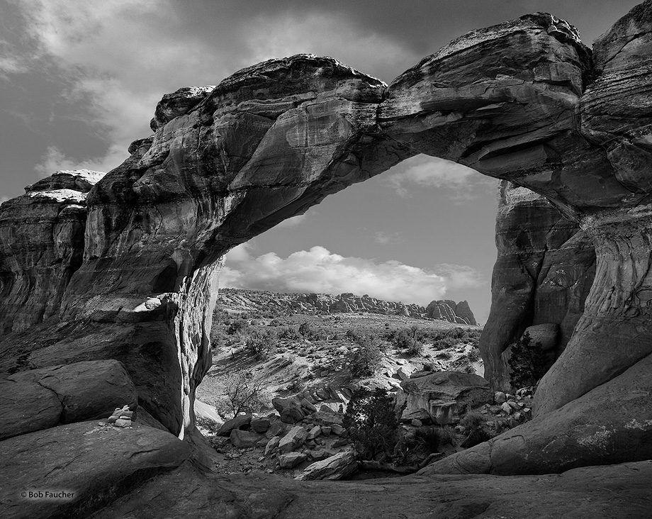 The sandstone fins of the Fiery Furnace are seen in the distance, approximately 1.2 miles away, as viewed through Broken Arch...
